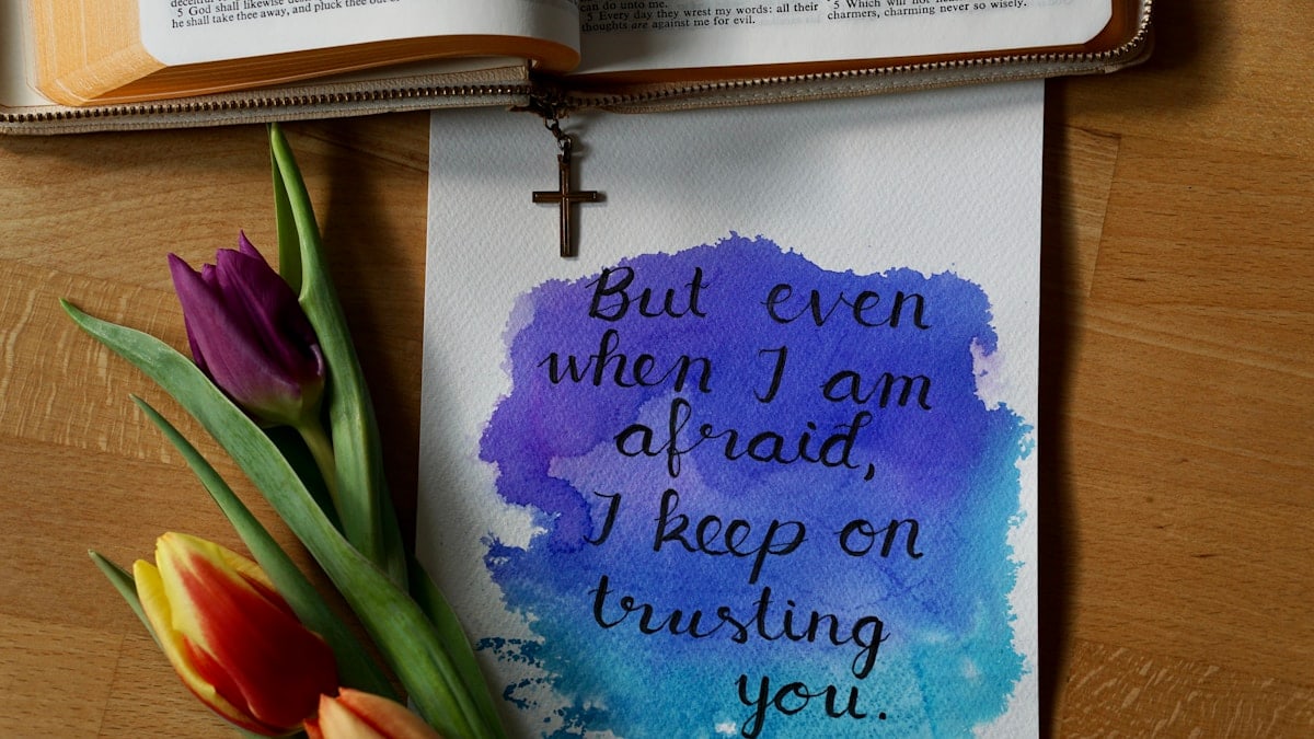 a watercolor painting of a bible and a flower