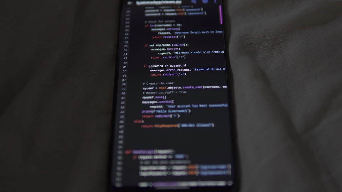 Close-up of a smartphone showing Python code on the display, showcasing coding and technology.